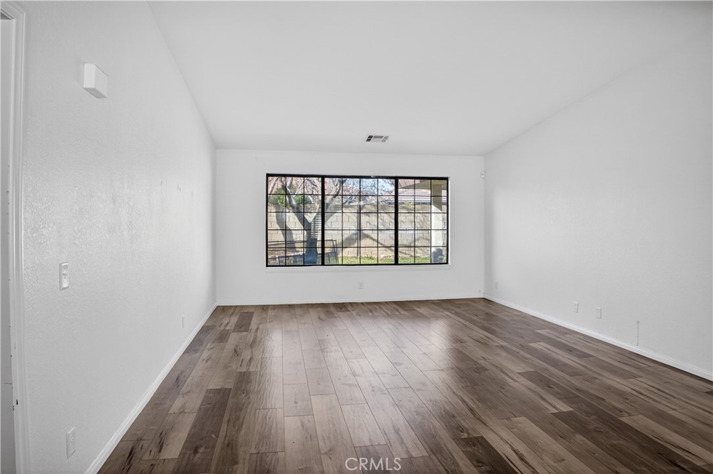 43631 37th Street West Lancaster, CA 93536 - Photo 4 of 38 an empty room with wooden floor and windows