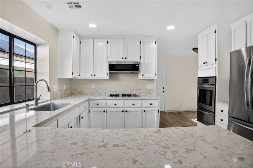 43631 37th Street West Lancaster, CA 93536 - Photo 10 of 38 a kitchen with stainless steel appliances granite countertop a refrigerator sink and cabinets