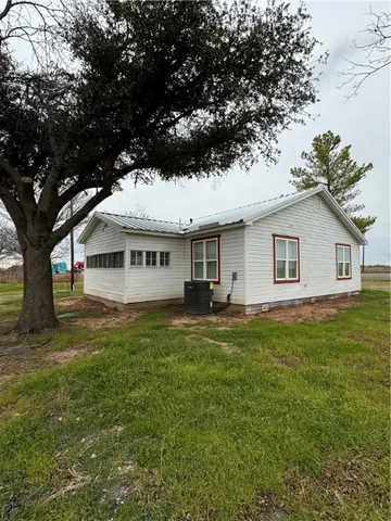 a view of a house with a big yard and large tree