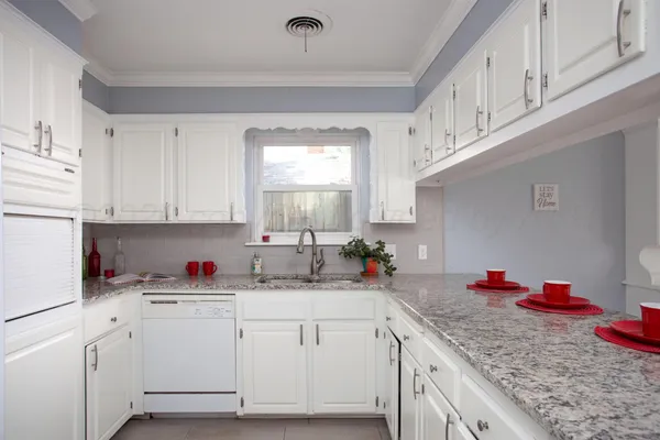 a kitchen with white cabinets sink and white appliances