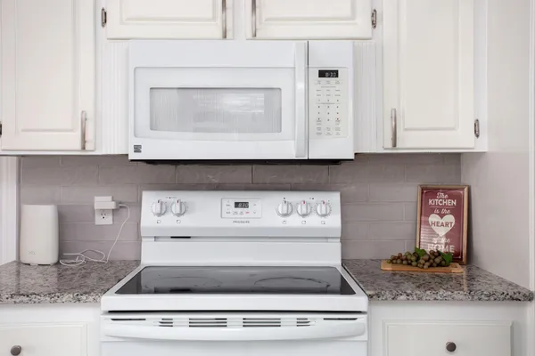 a stove top oven sitting inside of a kitchen