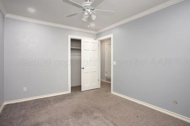 an empty room with a ceiling fan and a window