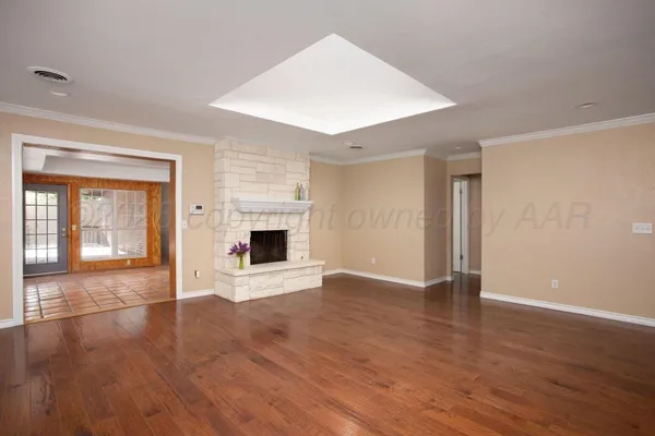 an empty room with wooden floor and fireplace