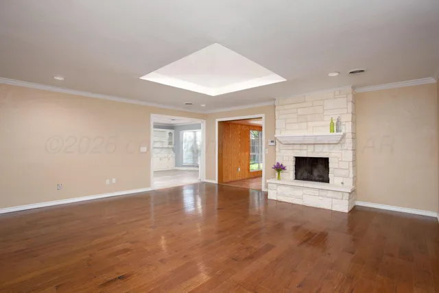 a view of empty room with wooden floor and fireplace