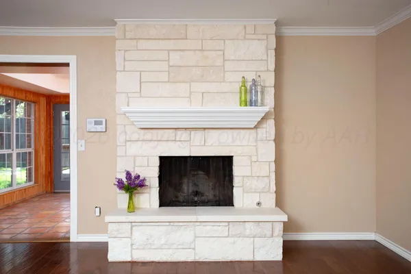 a living room with a fireplace and wooden floor