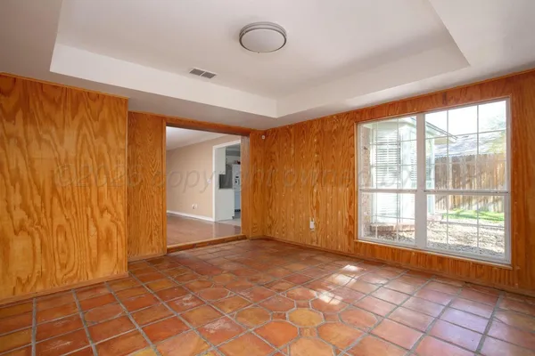 a view of an empty room with window and hardwood