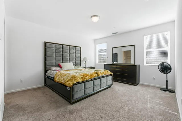 a bed sitting in a bedroom next to a window