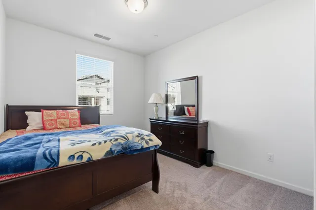 a bed sitting in a bedroom next to a window