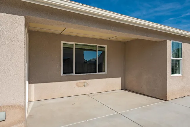 a view of a patio with table and chairs under an umbrella