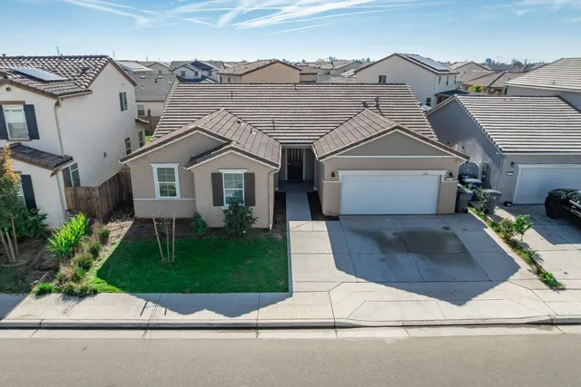 a view of a white house next to a yard