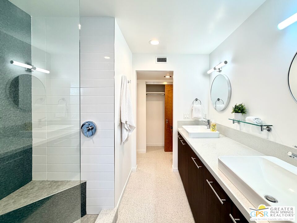 588 East San Lorenzo Road, Unit 104 Palm Springs, CA 92264 - Photo 26 of 74 a spacious bathroom with a double vanity sink mirror and shower