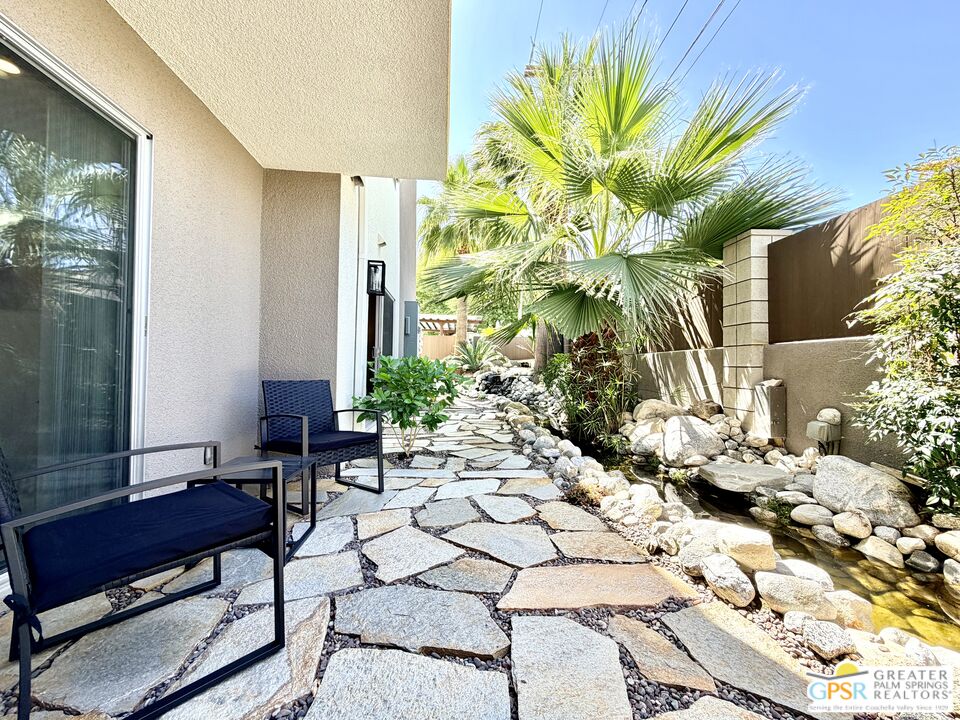588 East San Lorenzo Road, Unit 104 Palm Springs, CA 92264 - Photo 38 of 74 a view of a chairs and table in a backyard of a house