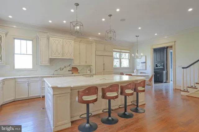 a kitchen with kitchen island granite countertop lots of wooden cabinets stainless steel appliances and dining table