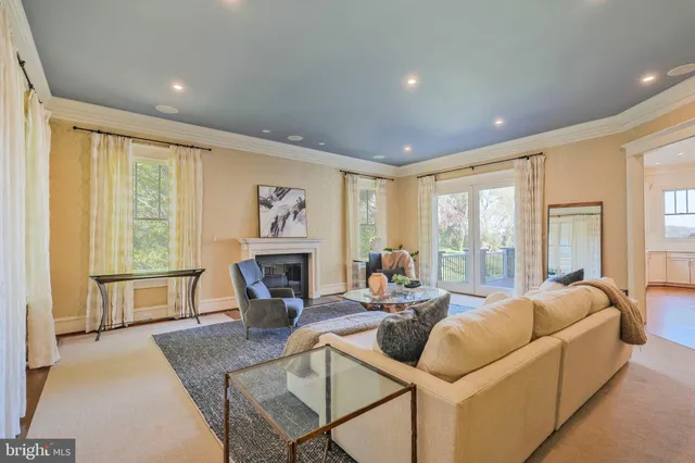 a living room with fireplace furniture and a large window