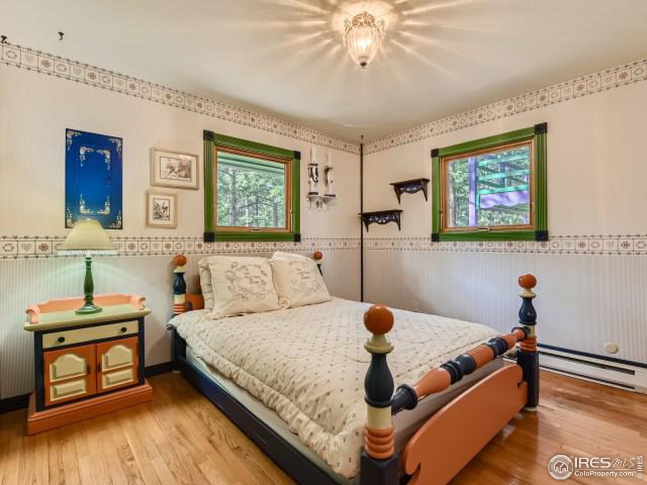 28 Wild Tiger Road Boulder, CO 80302 - Photo 12 of 39 a bedroom with a bed and a dresser with wooden floor