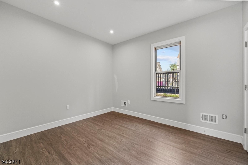 59 Locust Avenue, Unit 1R Wallington, NJ 07057 - Photo 6 of 10 wooden floor in an empty room with a window