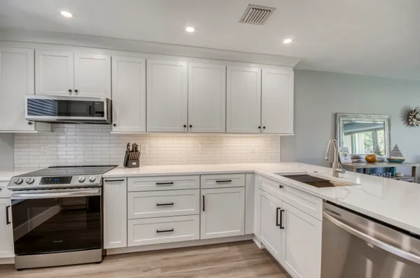 a kitchen with granite countertop a stove sink and cabinets