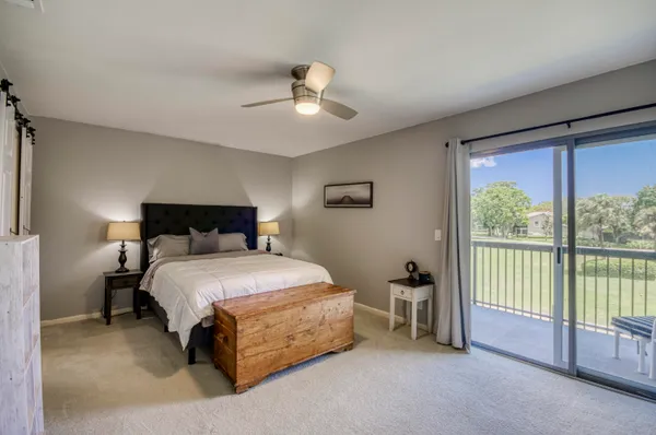a spacious bedroom with a bed and a chandelier