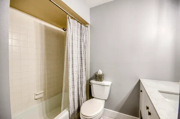 a white toilet sitting next to a bathroom sink and vanity