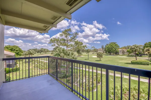 a view of a balcony with a yard