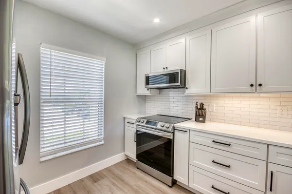 a kitchen with stainless steel appliances white cabinets and a stove top oven