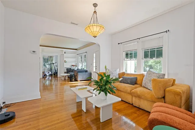 a living room with furniture a chandelier and a window