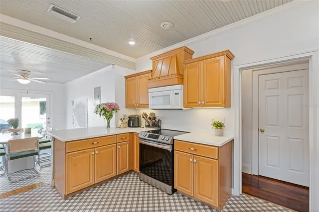 a kitchen with a sink a stove cabinets and wooden floor