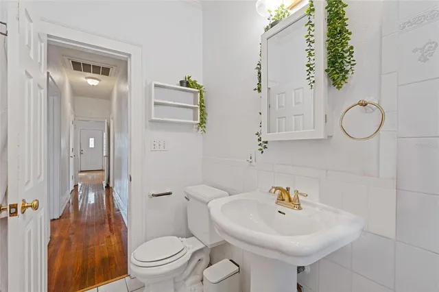 a bathroom with a sink a toilet and a mirror