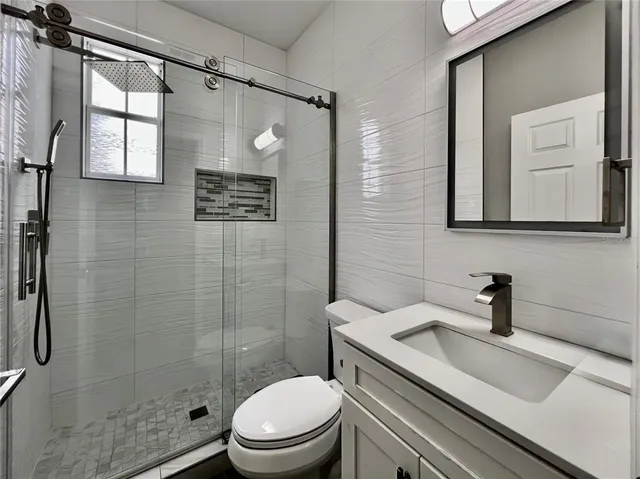 a bathroom with a sink a toilet and shower