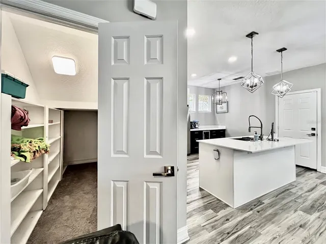 a large white kitchen with a large counter top appliances and cabinets