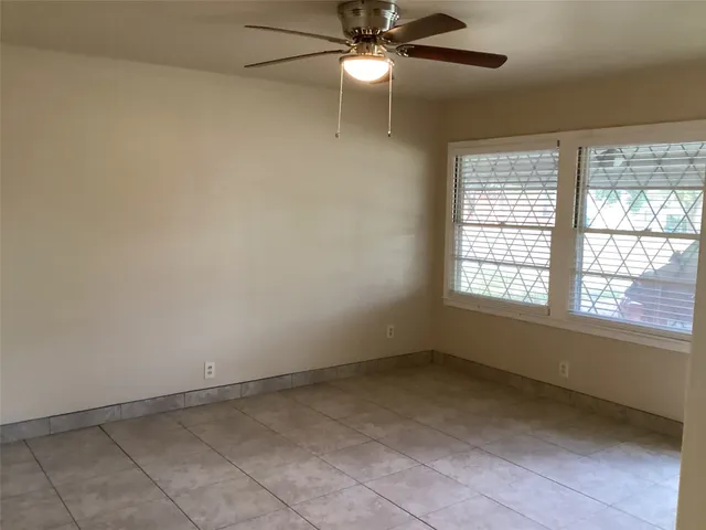 an empty room with a window and a fan