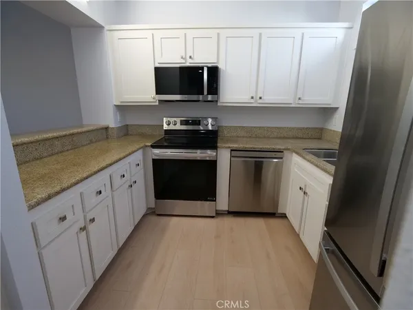 a kitchen with stainless steel appliances granite countertop a stove a sink and a microwave