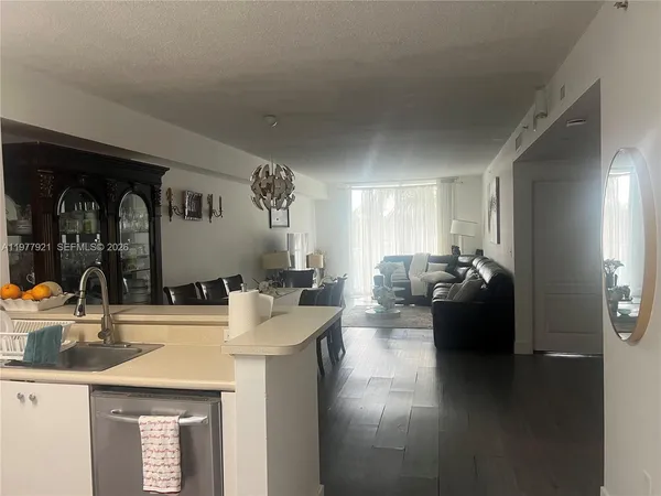 a kitchen with a sink dishwasher and a stove with wooden floor