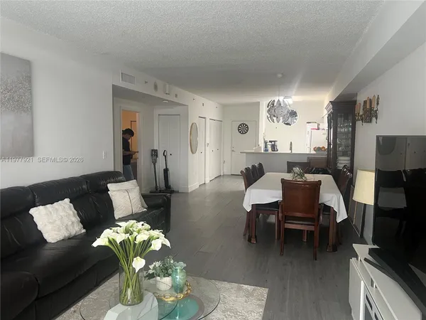 a living room with furniture flowerpot and a chandelier