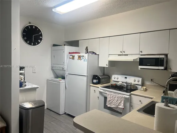 a kitchen with a refrigerator a stove and wooden floor