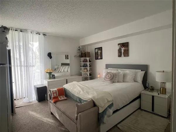 a bedroom with a bed couch and a large window