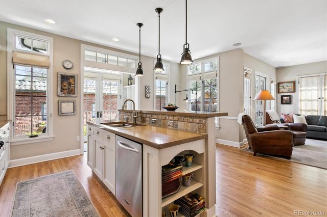 a living room with stainless steel appliances granite countertop furniture and a wooden floor