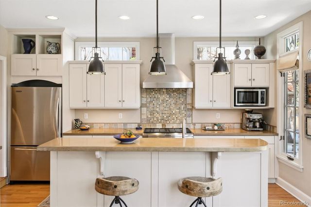 a kitchen with stainless steel appliances granite countertop a sink a refrigerator and a stove