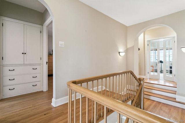 a view of a hallway with wooden floor and staircase