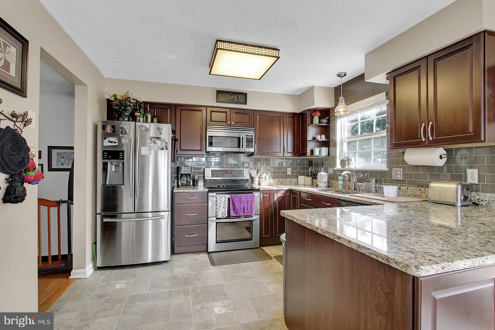 2101 Riding Crop Way Baltimore, MD 21244 - Photo 8 of 36 a kitchen with stainless steel appliances granite countertop a refrigerator a stove and a sink with wooden cabinets