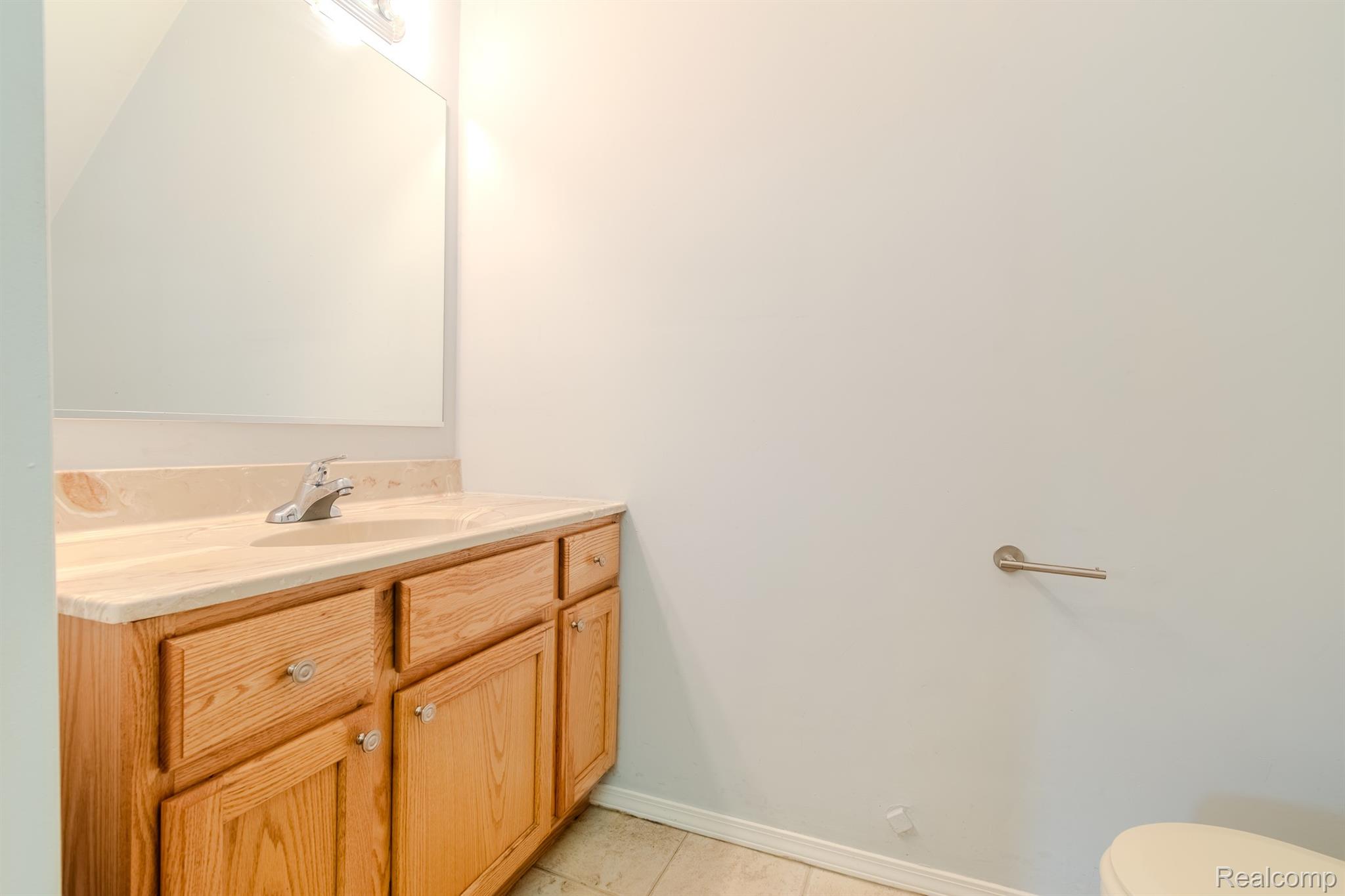 4644 South Rochester Road Royal Oak, MI 48073 - Photo 12 of 19 Wood-finish vanity with an integrated sink, polished chrome faucet, and expansive wall mirror