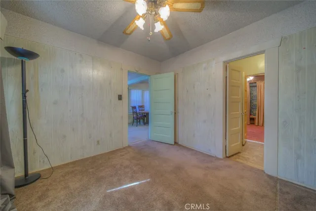 a view of a livingroom with a chandelier fan and a bathroom