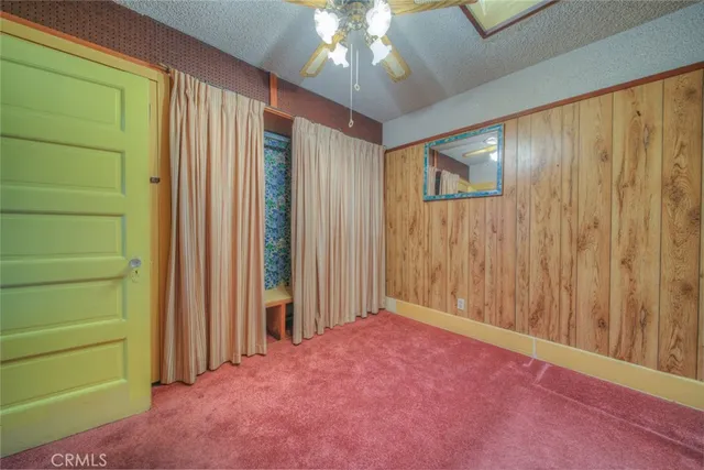 an empty room with floor to ceiling windows and chandelier fan