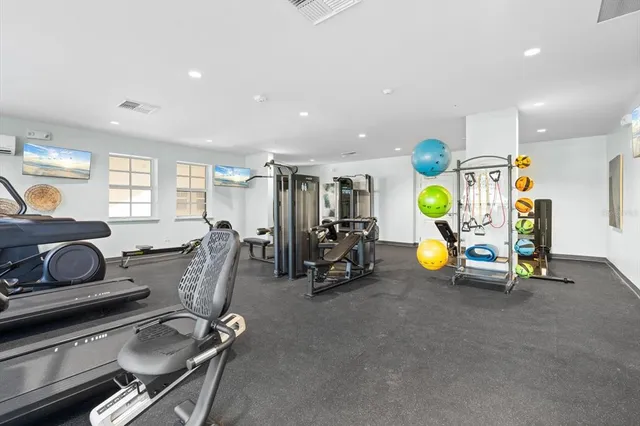 a room with gym equipment and large windows