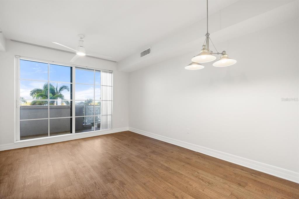 536 Bahia Beach Boulevard, Unit 102A Ruskin, FL 33570 - Photo 9 of 28 a view of an empty room with wooden floor and a window