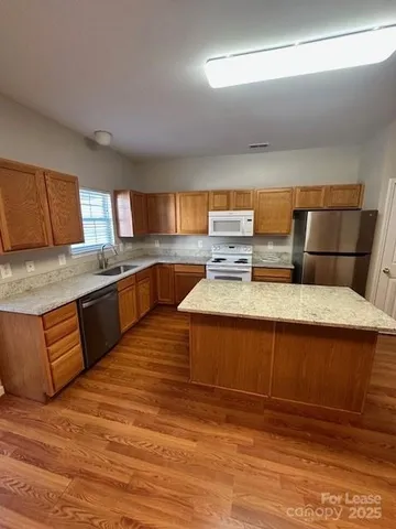 a kitchen with stainless steel appliances granite countertop a sink dishwasher stove and oven