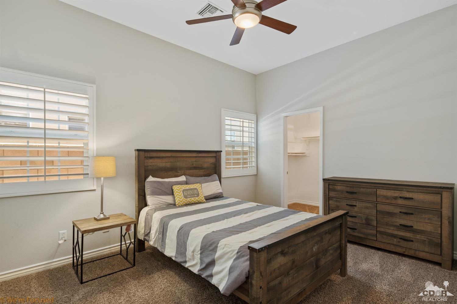 14 Tucson Circle Palm Desert, CA 92211 - Photo 12 of 20 a bedroom with a bed and a chandelier