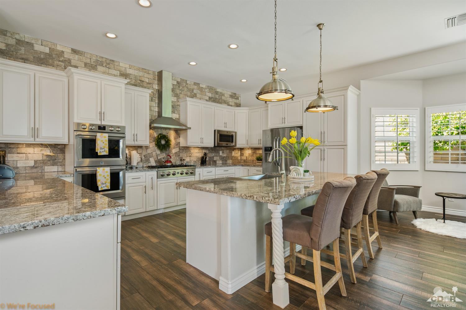 14 Tucson Circle Palm Desert, CA 92211 - Photo 3 of 20 a kitchen with stainless steel appliances kitchen island granite countertop a stove a sink and a wooden floors