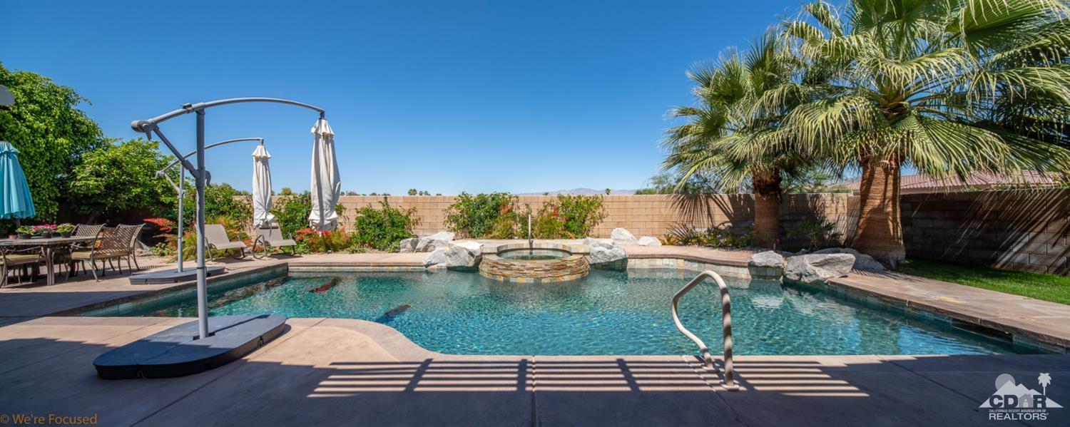 14 Tucson Circle Palm Desert, CA 92211 - Photo 4 of 20 a view of a swimming pool with a lounge chairs