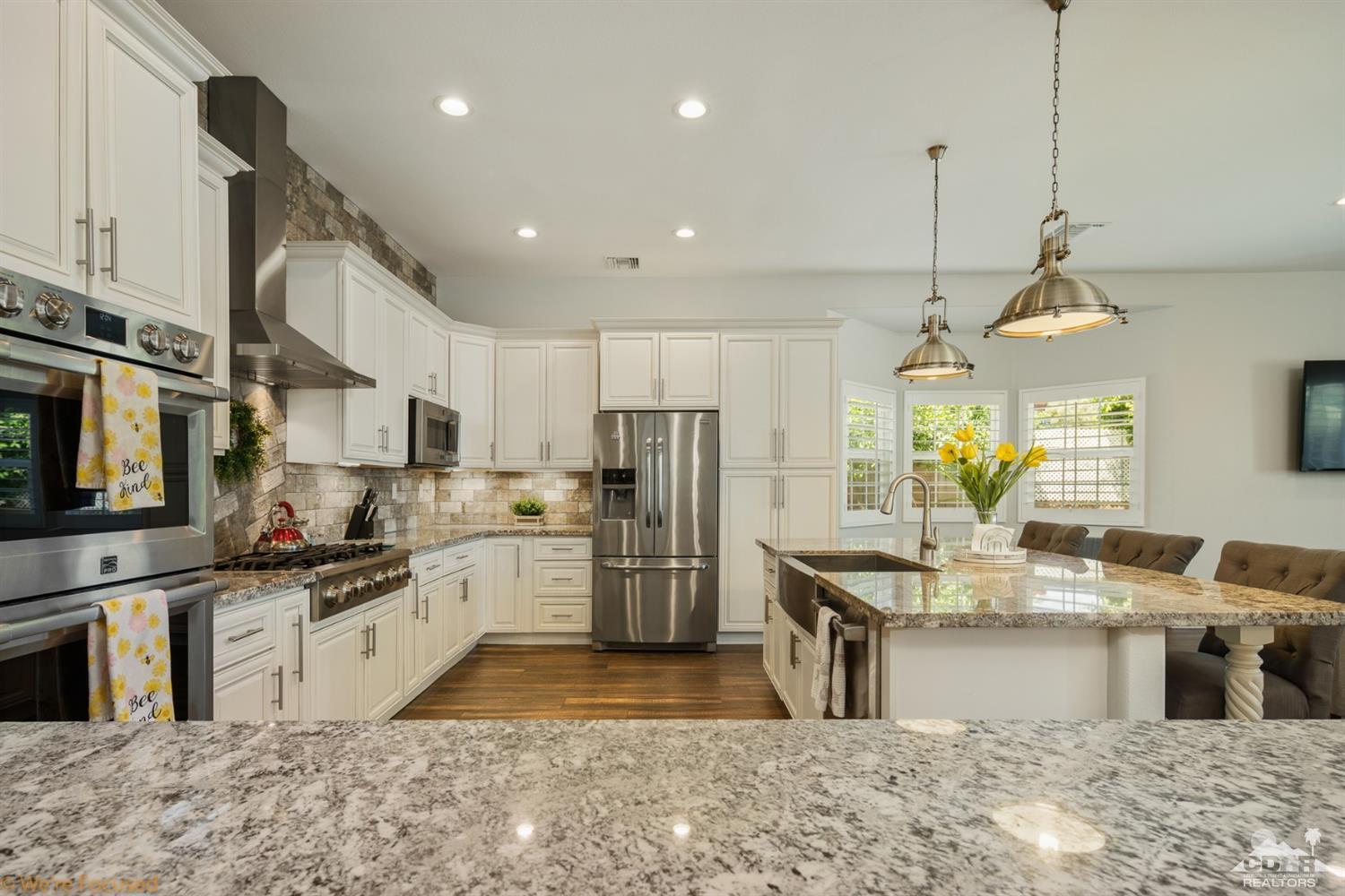 14 Tucson Circle Palm Desert, CA 92211 - Photo 7 of 20 a kitchen with stainless steel appliances granite countertop a sink a stove and a refrigerator
